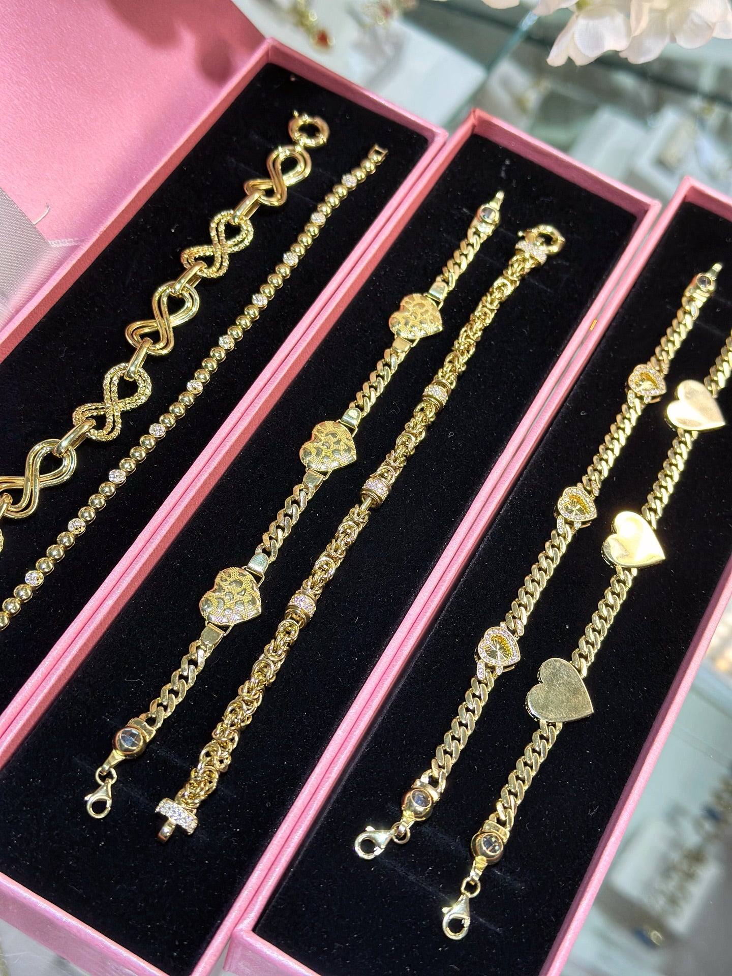 Tres bandejas con pulseras de oro surtidas listas para pedidos de mayoreo
