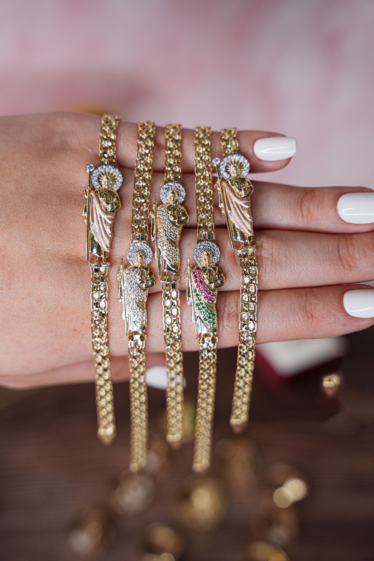 Mano mostrando cinco pulseras de oro de distintos diseños