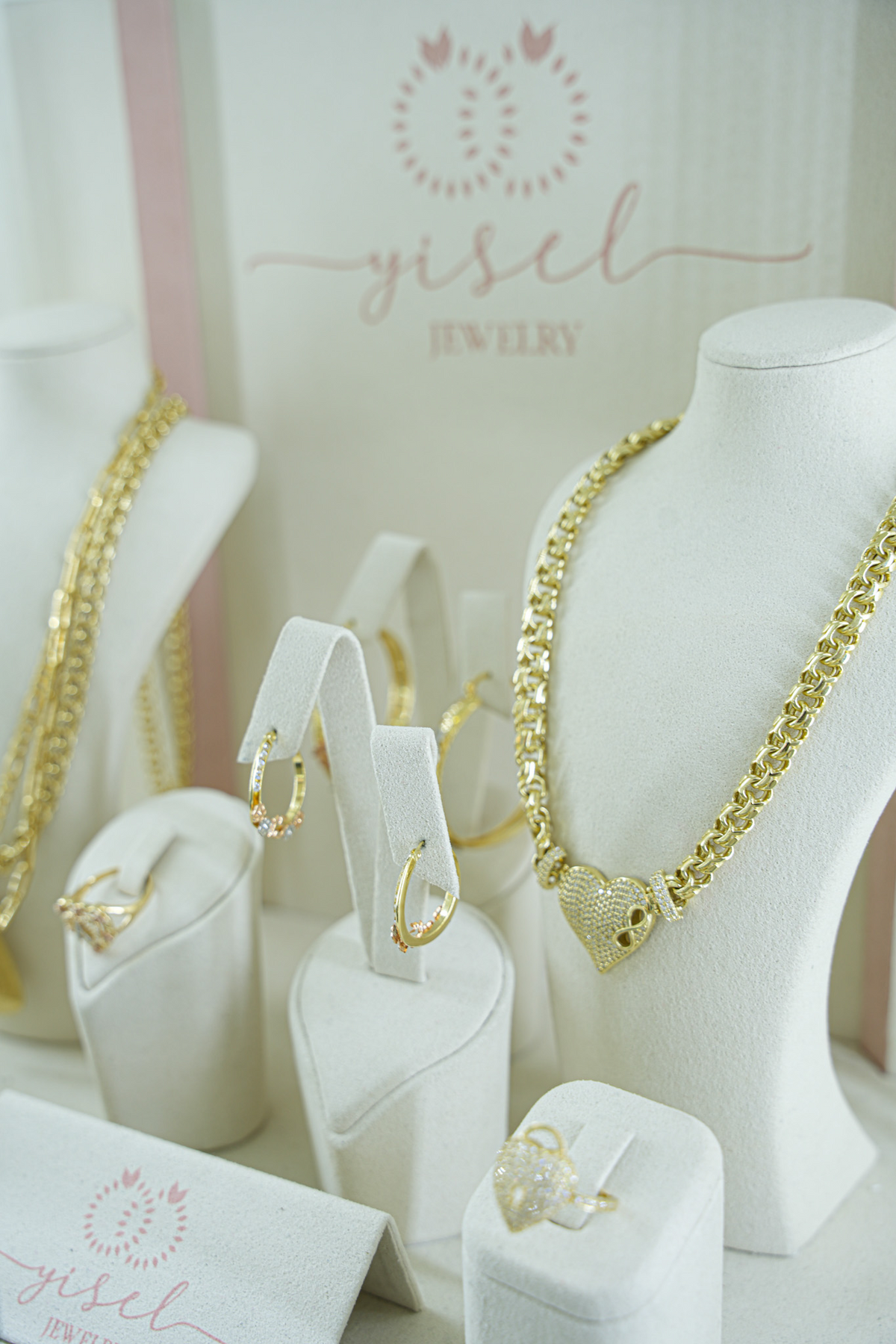 Exhibidor de la tienda con cadenas y dijes de oro sobre bustos blancos
