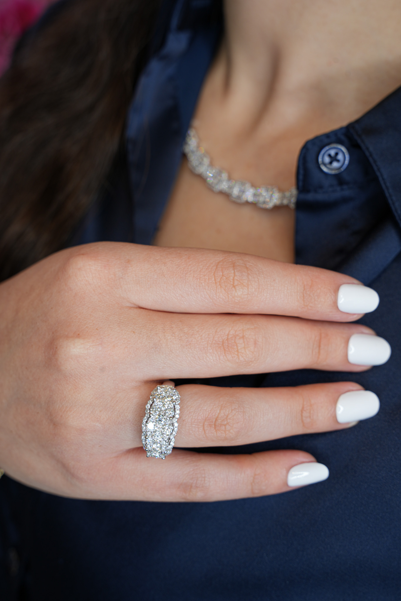 Anillo de diamantes y pulsera de tenis en la mano de una modelo